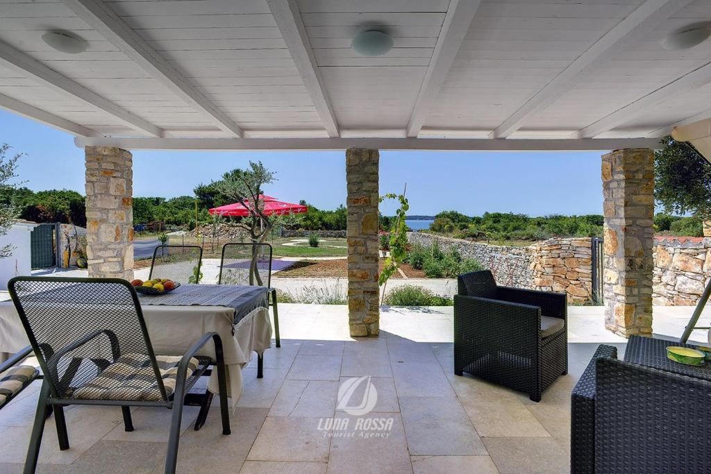 a patio with a table and chairs and a view of the ocean at Villa Emily in Peroj