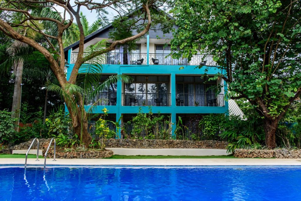 a blue house with a pool in front of it at Fig Tree Residences in Dar es Salaam