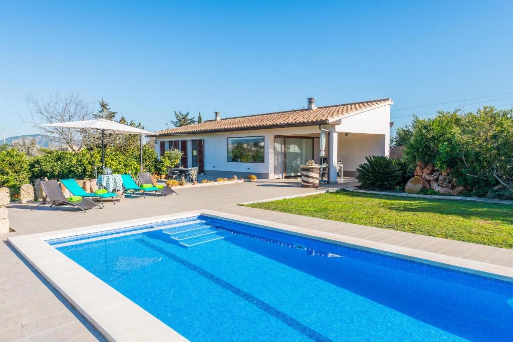 a swimming pool in front of a house at Es Serral in Sa Pobla