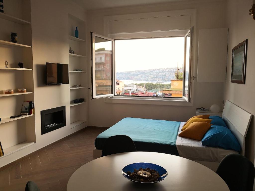 a bedroom with a bed and a table and a window at Casa Wenner 1 in Naples