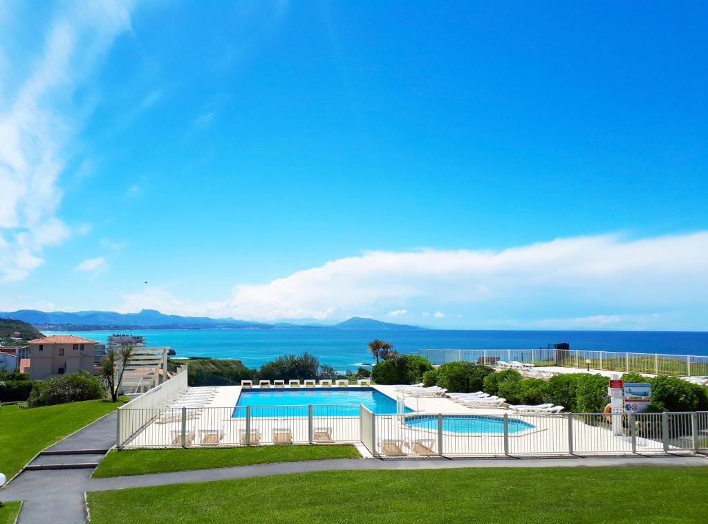 a view of a swimming pool and the ocean at Résidence Mer & Golf Eugénie in Biarritz