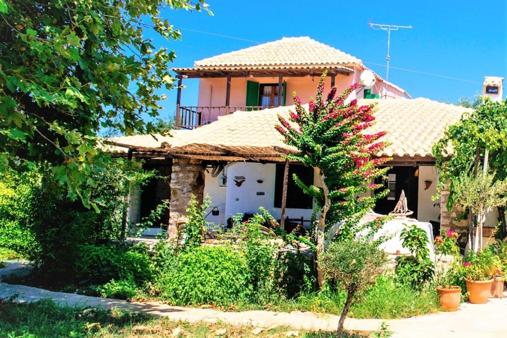 una casa con un porche y un árbol en Traditional house in a natural oasis, en Kánalos
