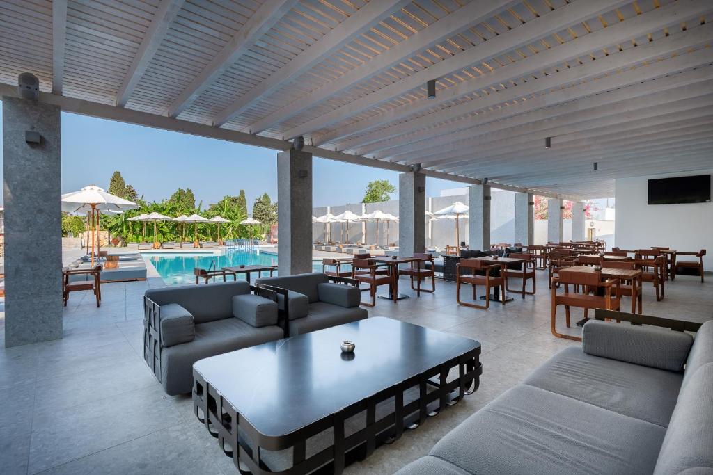 a living room with couches and tables and a pool at Diamond Boutique Hotel in Kos
