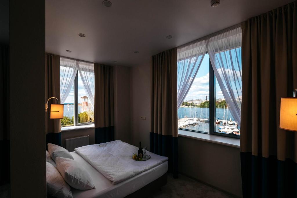 a bedroom with a bed with a view of the water at Komatek Hotel in Yekaterinburg
