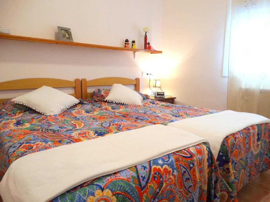 サン・フェリウ・デ・ギホルスにあるDEULOFEU, BONITO APARTAMENTO EN EL CENTRO DE SANT FELIU CON WIFI GRATUITOのベッド1台(カラフルな毛布、枕2つ付)