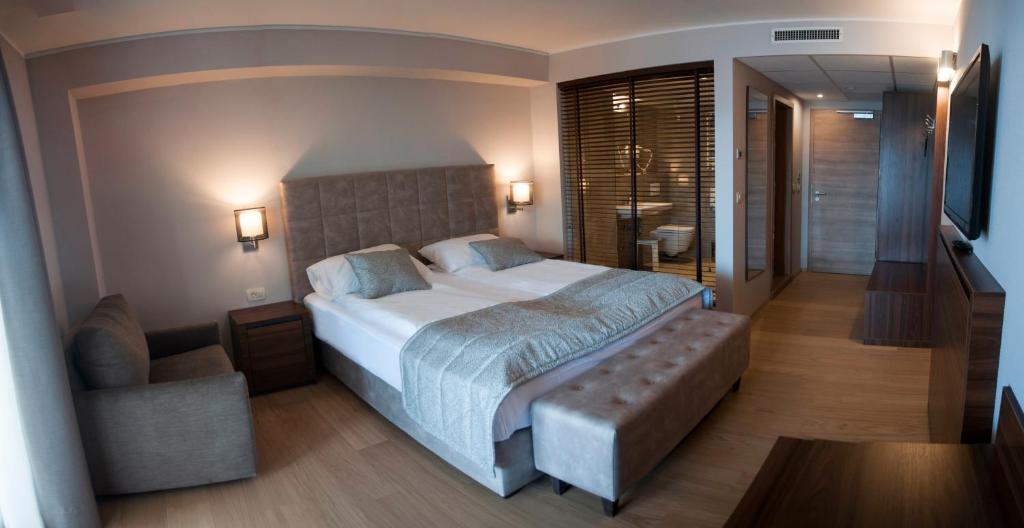 a bedroom with a large bed and a television at Hotel Marina in Izola