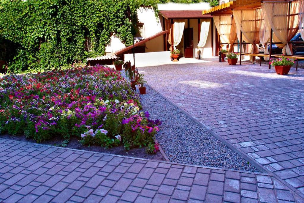 um jardim com flores no meio de um passeio em Hotel 12 em Carcóvia