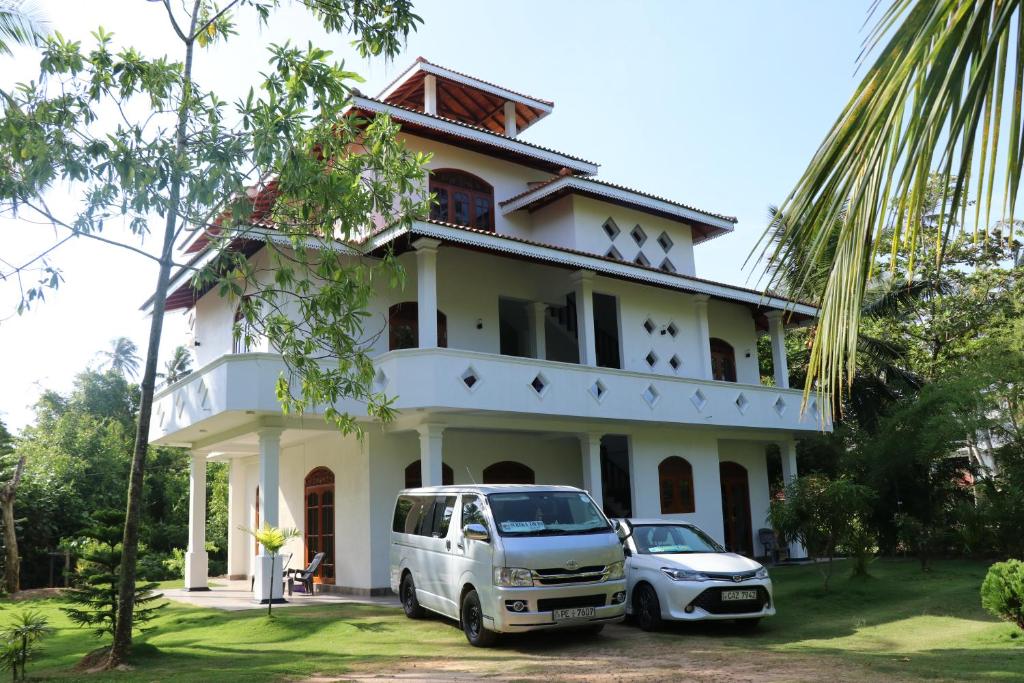 a van parked in front of a white house at Villa Sureka in Hikkaduwa