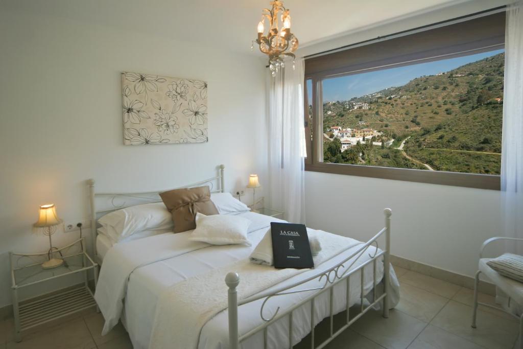 a bedroom with a bed with a book on it at Hotel La Casa in Torrox