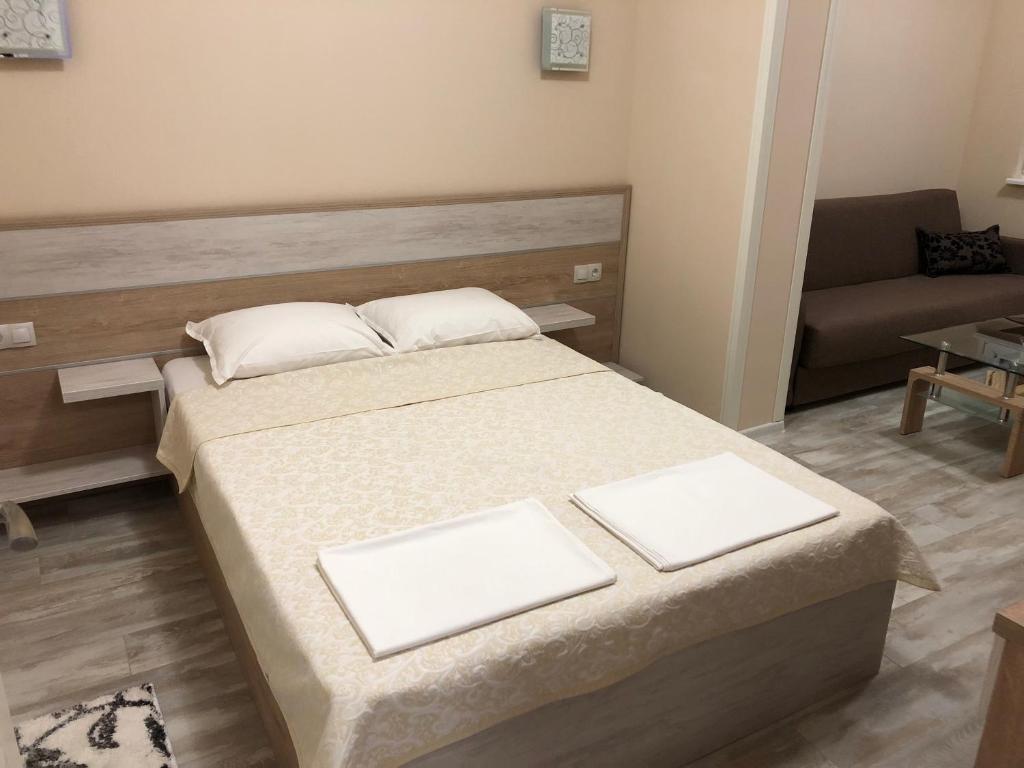 ein kleines Zimmer mit einem Bett und einem Sofa in der Unterkunft ФЛАМА РЕЗИДЕНТС in Plowdiw