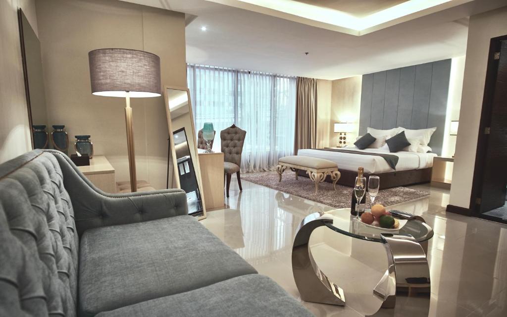een woonkamer met een bank en een bed bij J7 Hotel in Iloilo City
