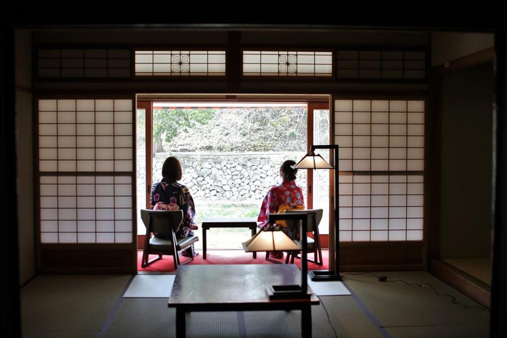 two women sitting in chairs looking out of a window at OkutsuHotSpa IkedayaKajikaen in Kagamino
