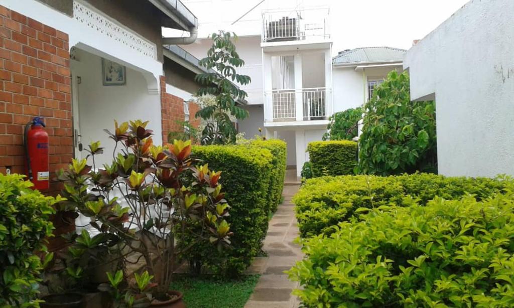 a courtyard of a house with bushes and a fire hydrant at Tourist Nest Hotel in Kampala