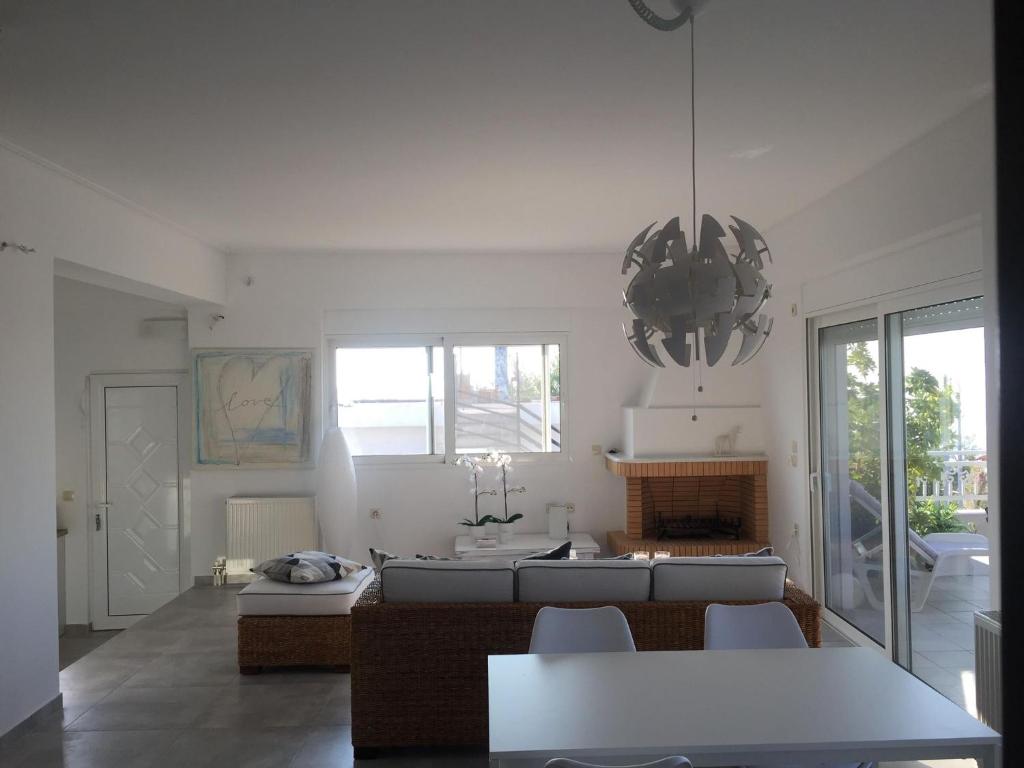 sala de estar con sofá y mesa en Yoga Euphoria seaside apartment, en Artemida