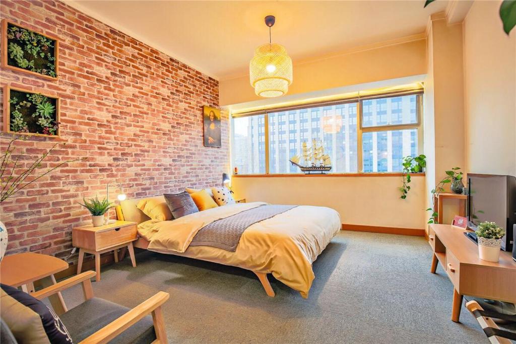 a bedroom with a bed and a brick wall at Hangzhou Xihu District ·Huanglong Sports Center Locals Apartment 00147450 in Hangzhou