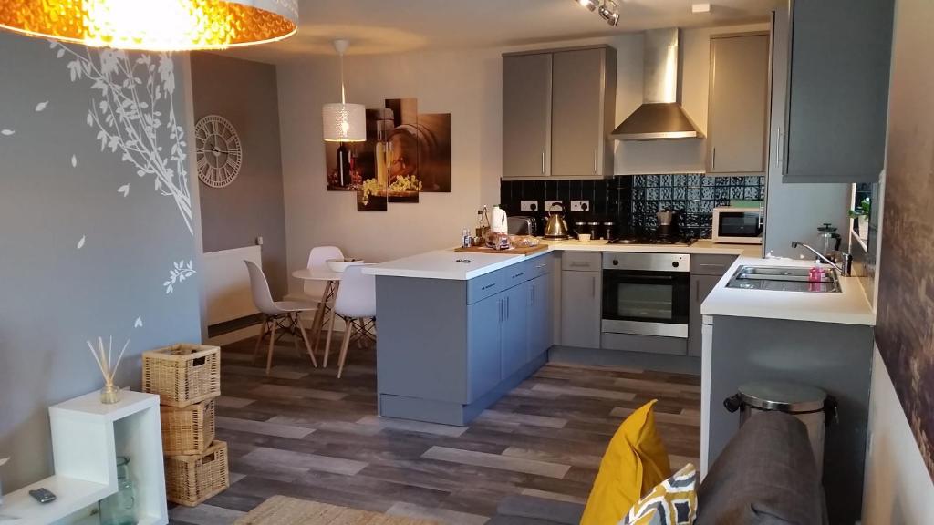 a kitchen with white cabinets and a dining room at New Contemporary Flat minutes from Airport & NEC in Marston Green