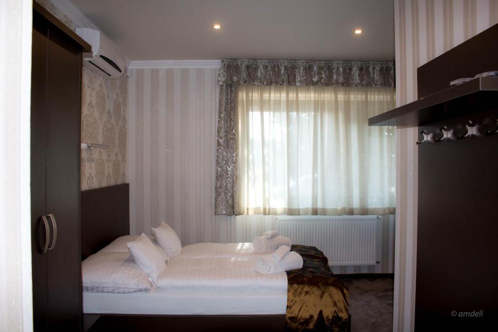 ヤースベレニにあるControl Motelのベッドルーム1室(白いシーツ付きのベッド1台、窓付)