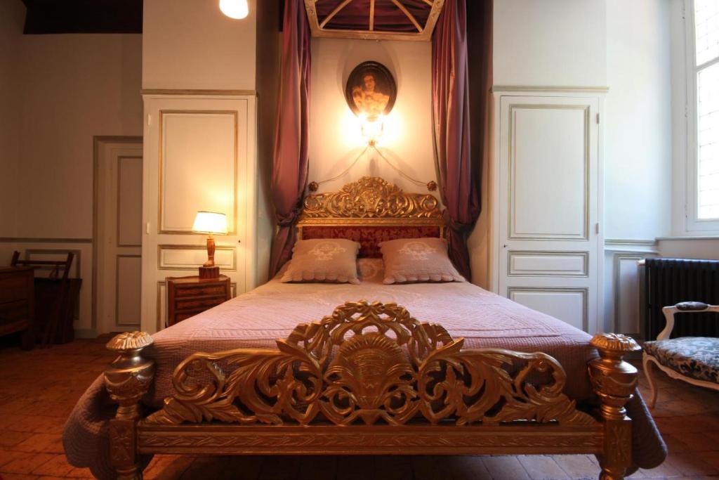 a bedroom with a large bed with a wooden frame at Château de Varennes in Varennes-lès-Mâcon