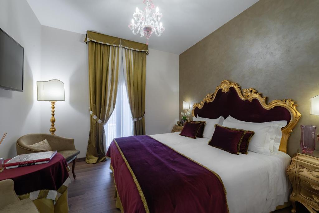 a bedroom with a large bed and a chandelier at Hotel Concordia in Venice
