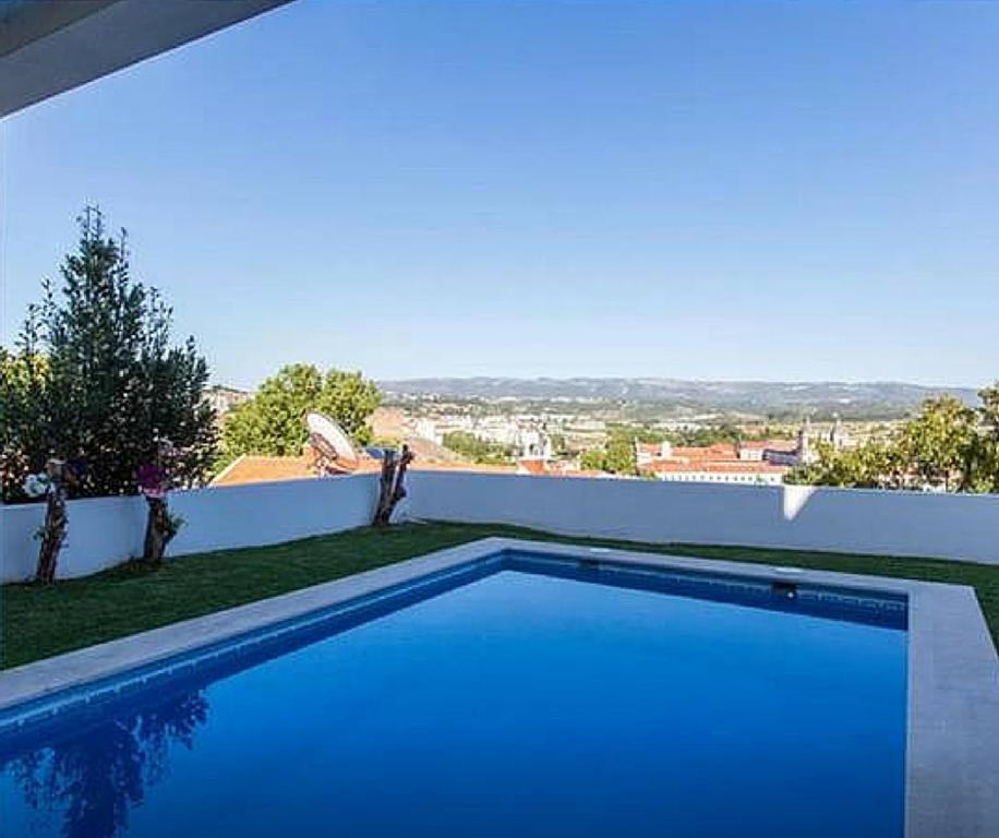 a blue swimming pool on top of a house at Stunning view Alcobaça in Alcobaça