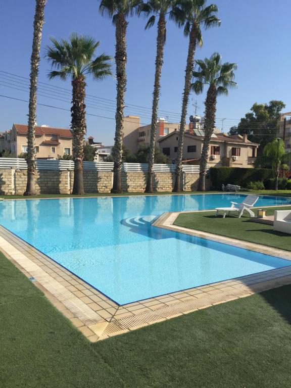 ein großer Pool mit Palmen im Hintergrund in der Unterkunft Apartments Old Bridge in Limassol
