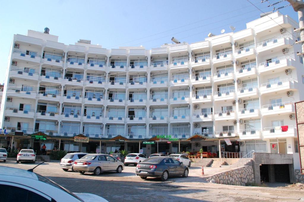 ein großes weißes Gebäude mit davor geparkt in der Unterkunft Hakan Apart Otel in Kizkalesi