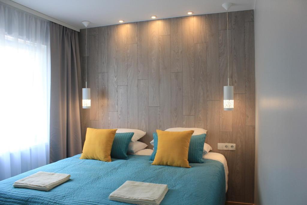1 dormitorio con 1 cama con sábanas azules y almohadas amarillas en Kaevu 14, en Pärnu
