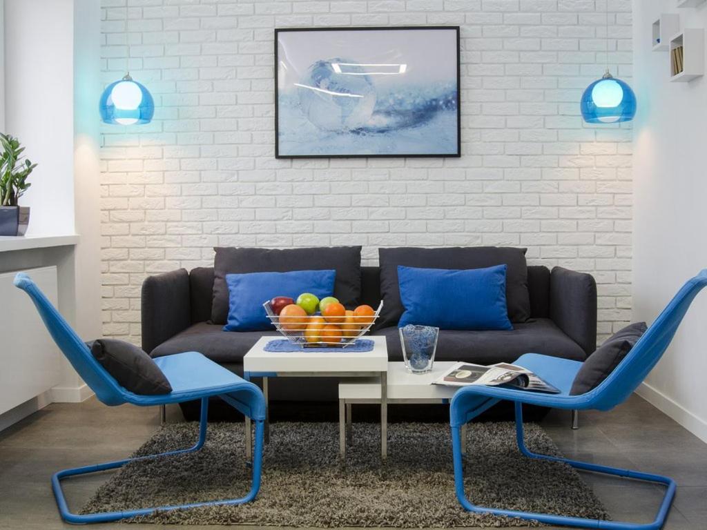 a living room with a couch and blue chairs at Apartament Skoczyńskiego 11a in Stalowa Wola