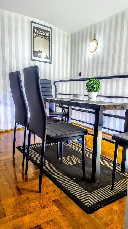 een eettafel met twee stoelen en een tafel met een plant bij Basilica Centrum Apartment Budapest in Boedapest