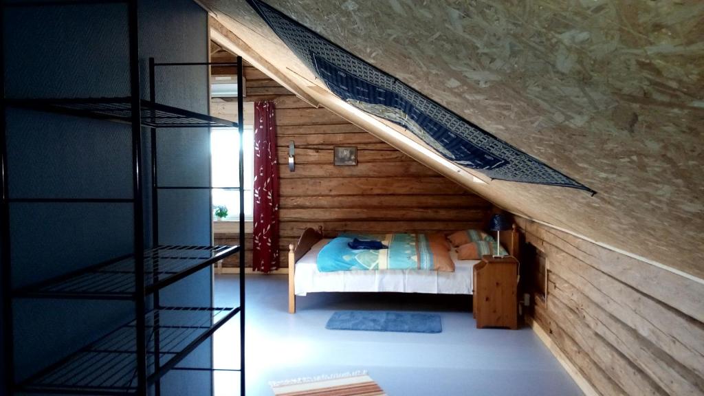 1 dormitorio con 1 cama y pared de madera en Villa Moni, en Lungsjön