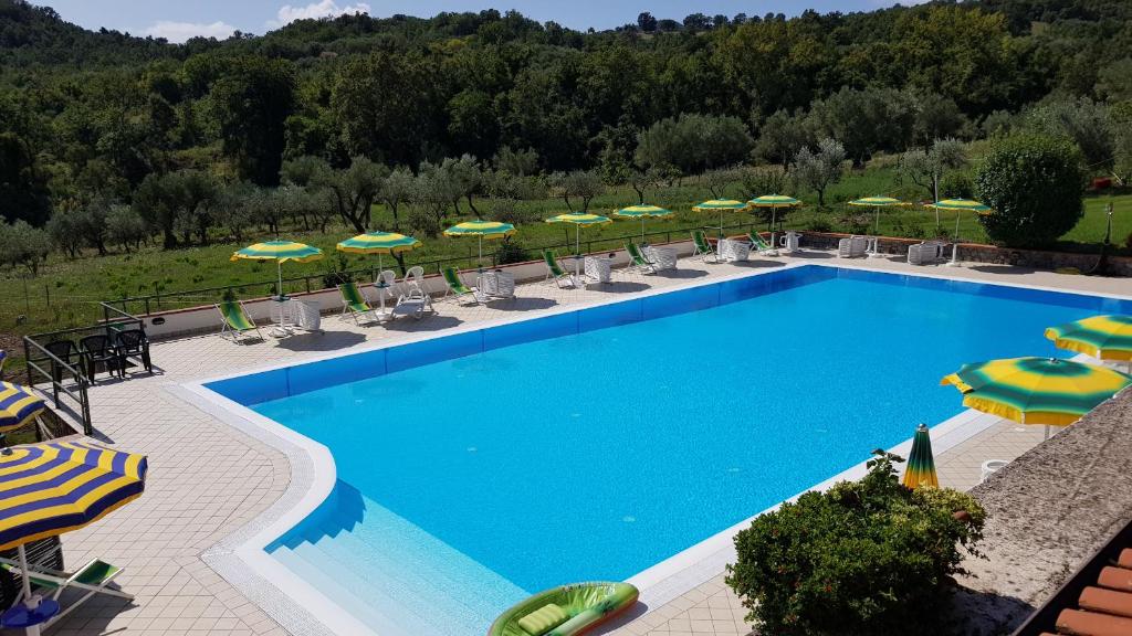 a large swimming pool with chairs and umbrellas at Bel Tempio in San Giovanni a Piro