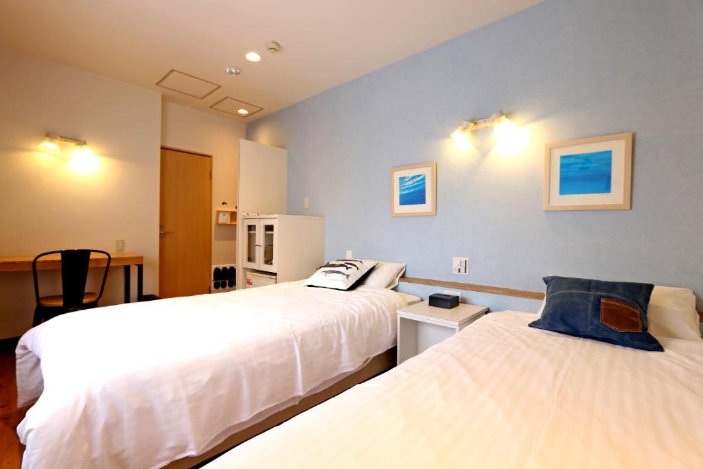 大阪市にあるHotel 3 O'Clock Tennojiのベッドルーム1室(ベッド2台、テーブル、椅子付)