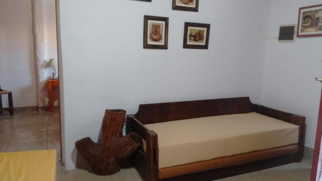 Cama en habitación con pared blanca en El Encuentro en Juana Koslay 