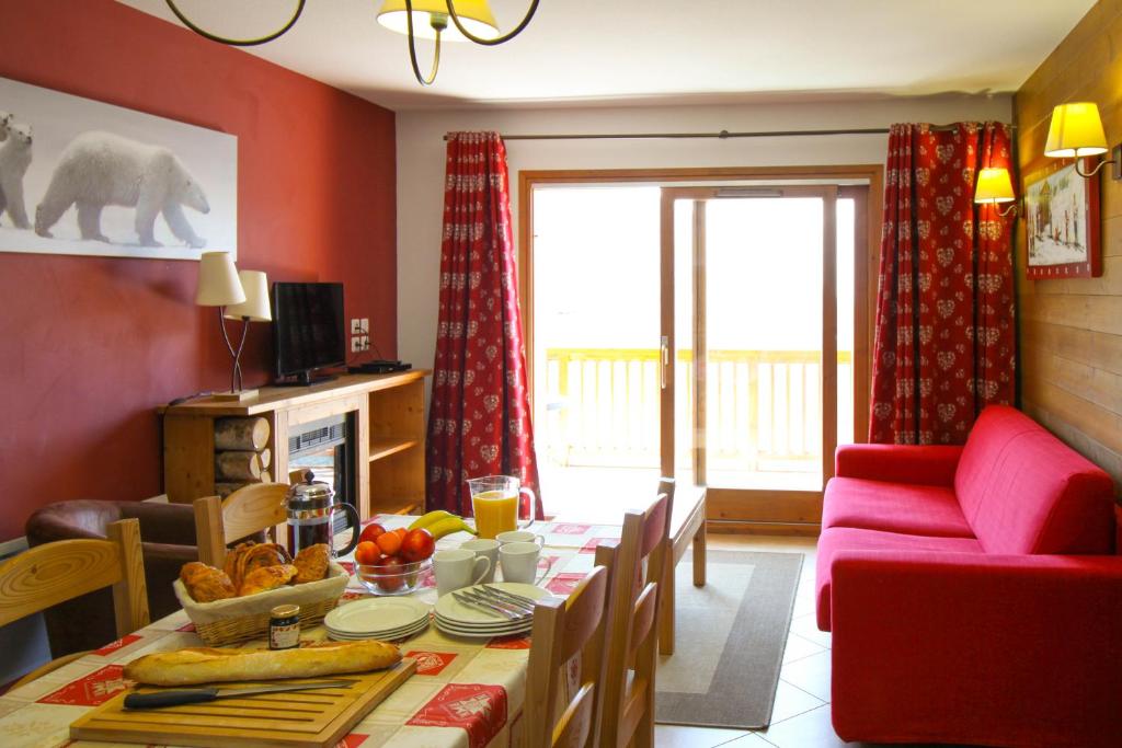 uma sala de estar com uma mesa e um sofá vermelho em Time to Ski - La Niche em Sainte-Foy-Tarentaise