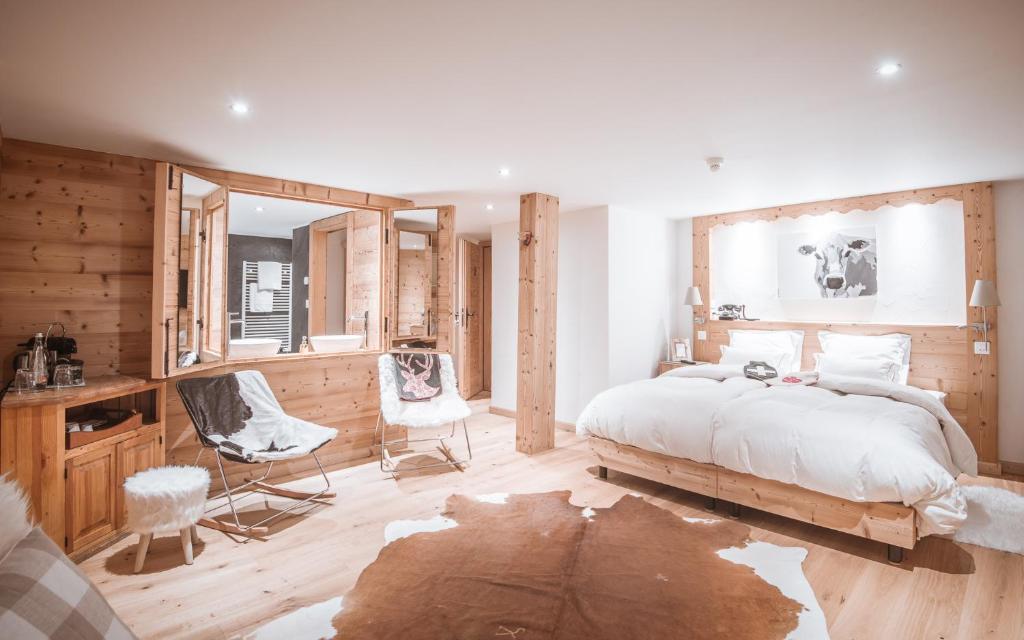 Schlafzimmer mit einem großen Bett, einem Schreibtisch und Stühlen in der Unterkunft Lifestyle Rooms & Suites by Beau-Séjour in Champéry