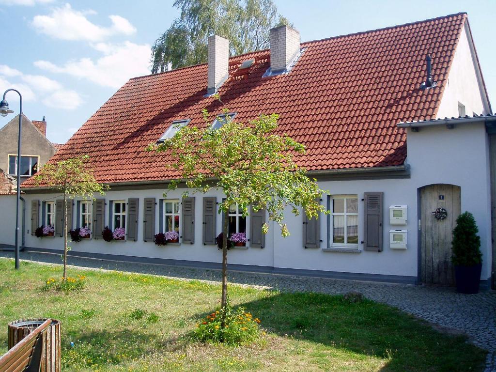 ein weißes Haus mit rotem Dach in der Unterkunft Die alte Stadtmühle von Kloster Zinna in Jüterbog