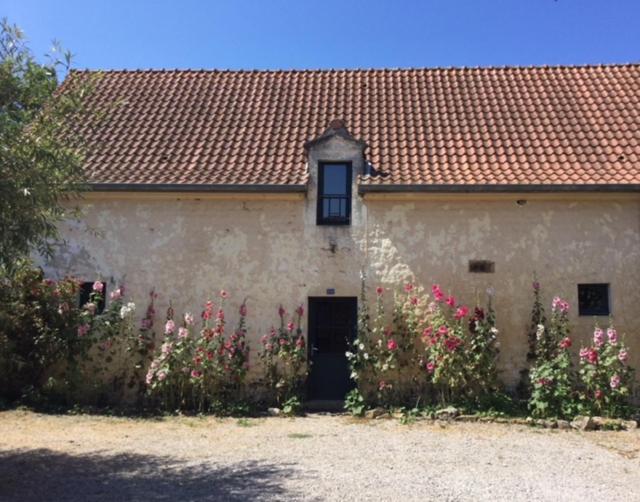 un edificio bianco con fiori rosa di fronte di Gîte du Mont de la Louve a Bazinghen