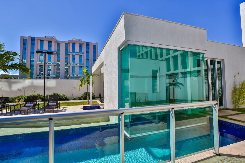 a house with a swimming pool next to a building at Jade Hotel Brasília in Brasilia