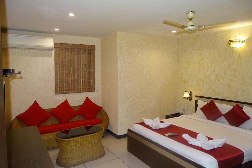 um quarto de hotel com duas camas e um sofá em Hotel Sunshine Airport em Mumbai