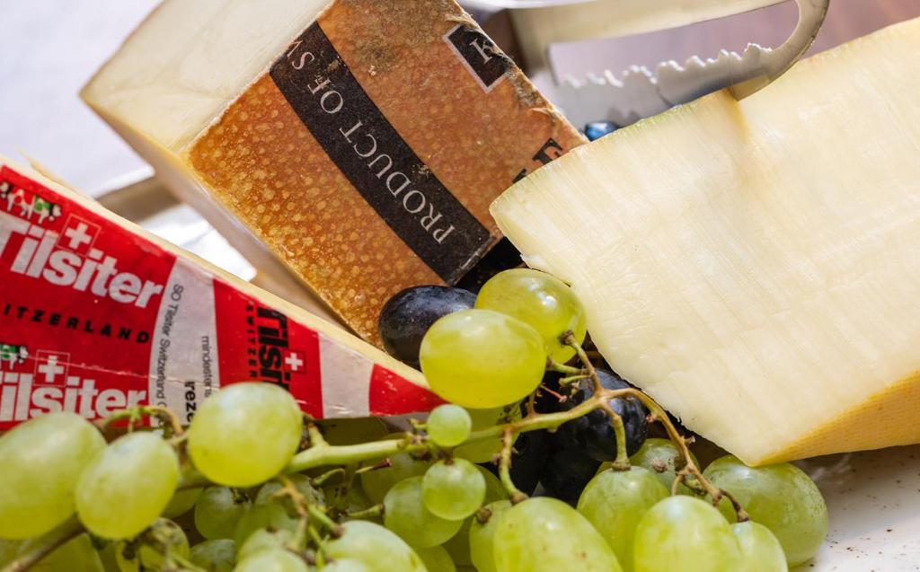a bunch of grapes and cheese on a table at Hotel Scheuble in Zürich