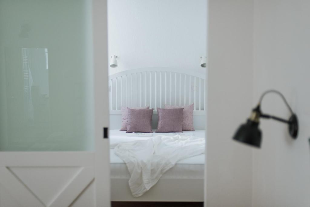 a bedroom with a bed with purple pillows and a lamp at Lizmary's Wonderland in Budapest