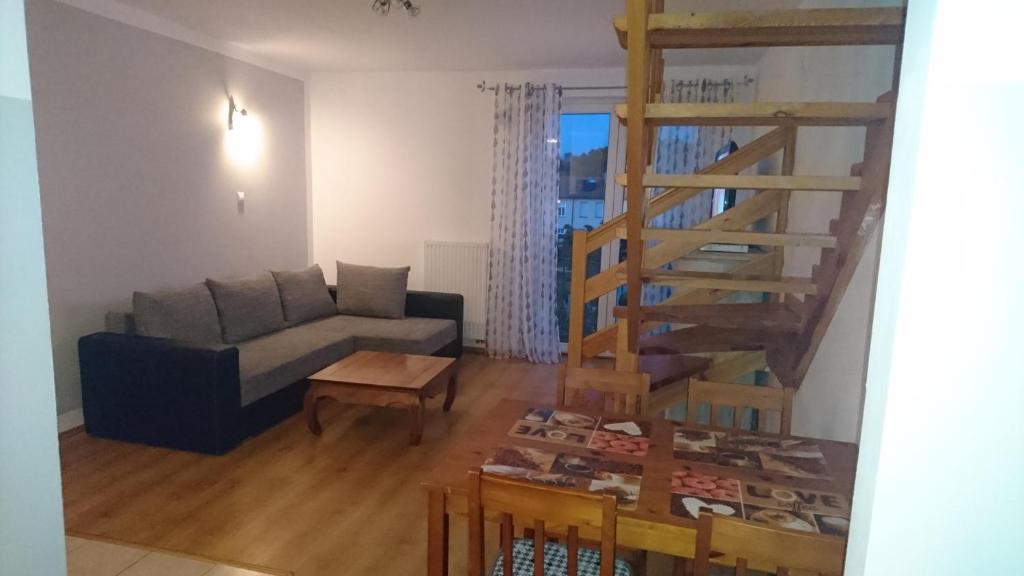 a living room with a couch and a staircase at Apartament w centrum "Jagoda"przy Placu Neptuna in Międzyzdroje