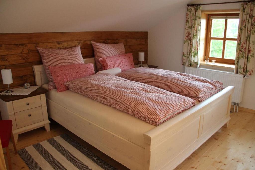 una camera da letto con un grande letto con cuscini rosa di Schreinerhäusl a Neuschönau