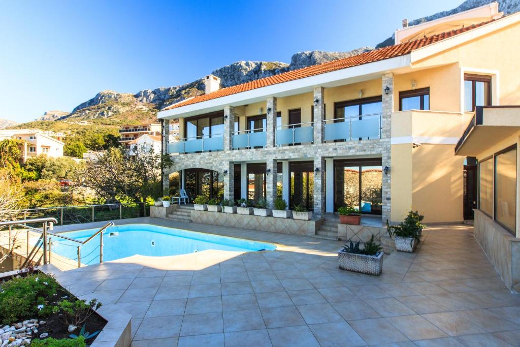 una casa con piscina frente a ella en Villa Narcissus Montenegro KO Sveti Stefan, en Sveti Stefan