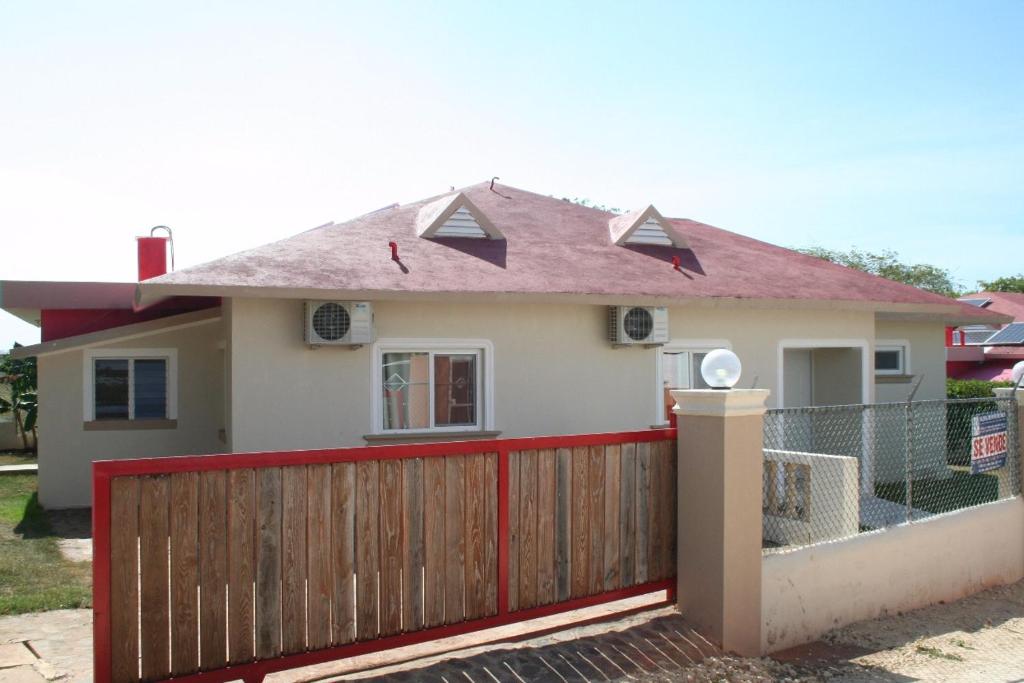 a house with a red fence in front of it at Apartamentos y Villas Michaela in Sosúa