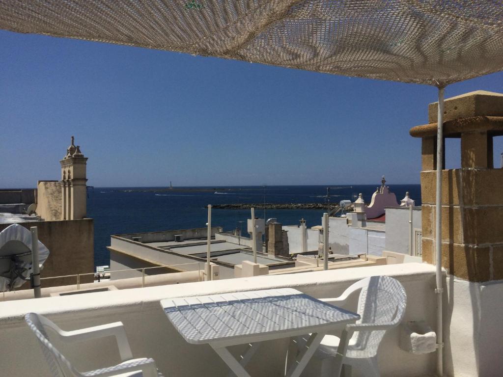 a table and chairs on a balcony with a view of the ocean at Corte De Noie Appartamenti Gallipoli in Gallipoli