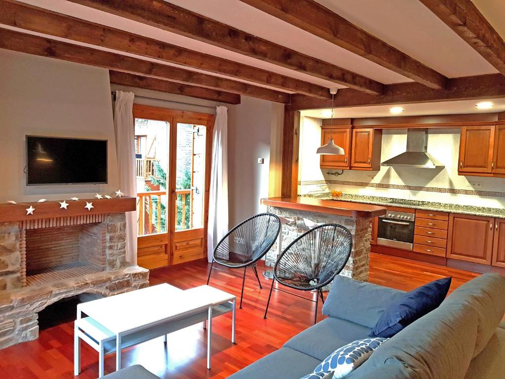 a living room with a couch and a fireplace at Apartamento dúplex Esterri d'Aneu in Esterri d'Àneu