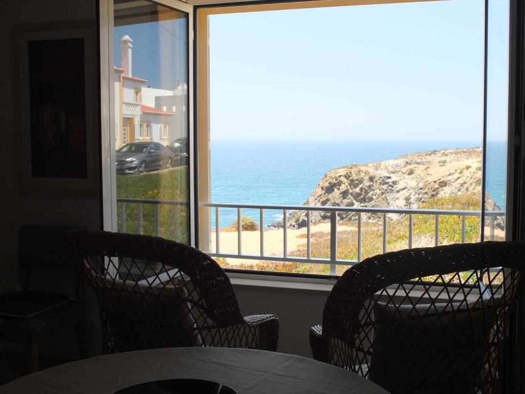 a dining room with a view of the ocean at LAJINHA MAR-BEACH APARTMENT-Zambujeira Mar in Zambujeira do Mar