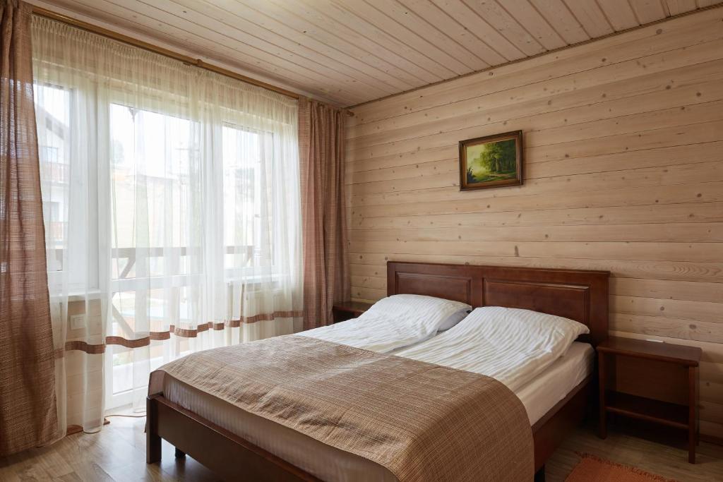 a bedroom with a bed in a room with a window at Zlata in Bukovel