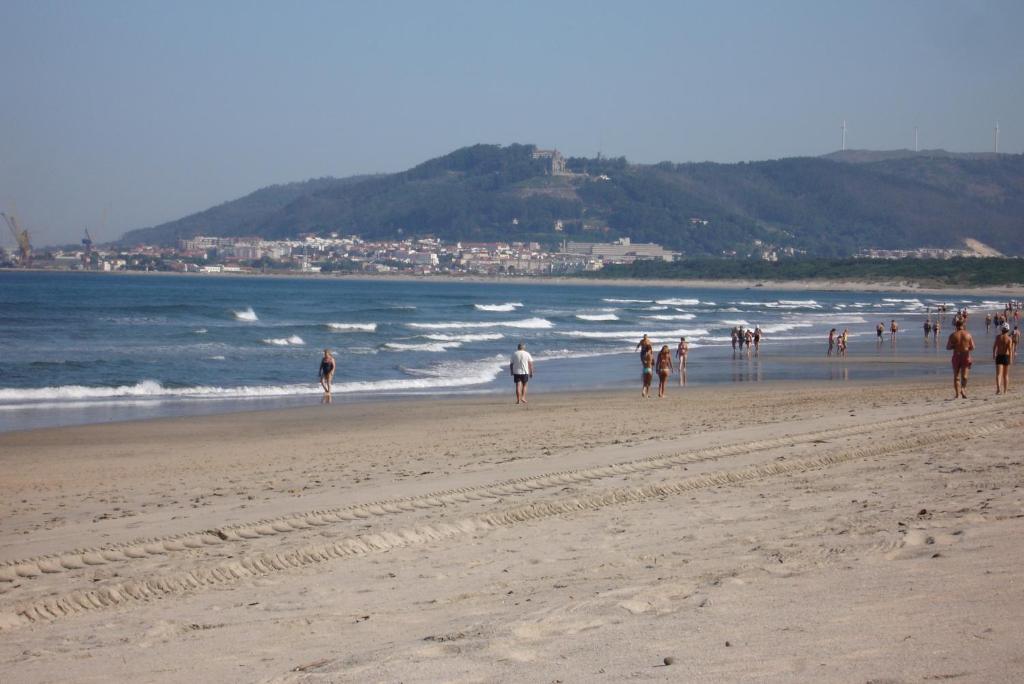 AmorosaにあるApartamento da Praia da Amorosaの海岸を歩く人々